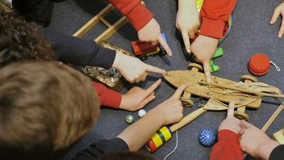 Group of children all playing with wooden toys